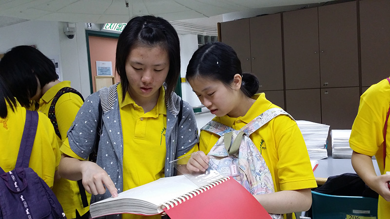 两位参加者尝试「阅读」点字书